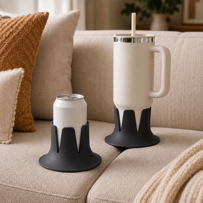The drink holder in Charcoal on a couch cushion, holding a can and a tumbler.